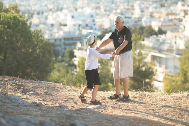 Old and Young Family generation and relations concept Retired grandfather and grandson playing with on sunny day enjoying outdoor