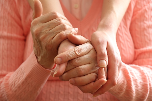 Old and young holding hands, closeup