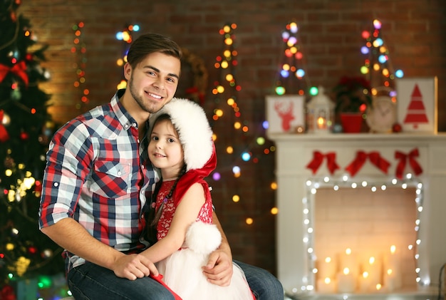 Older brother and little sister sitting in Christmas living room