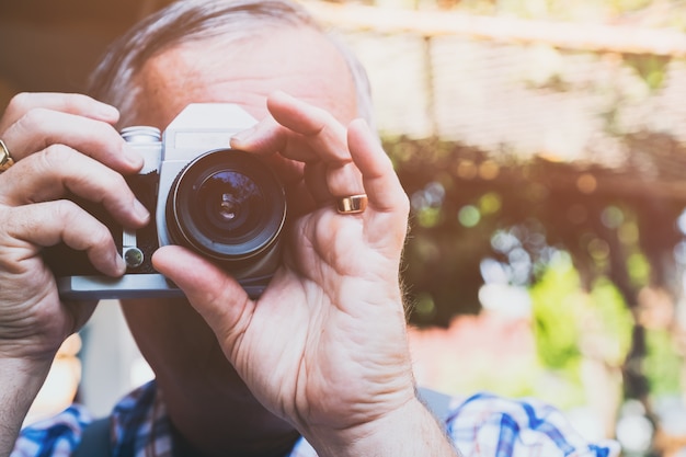 older hipster man with a old vintage camera