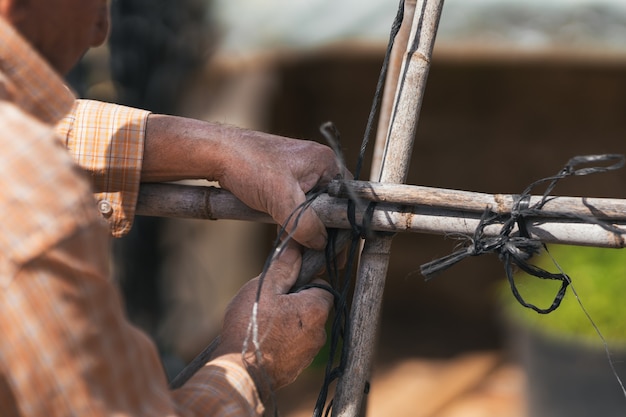 Older man handling materials to build a vegetable garden