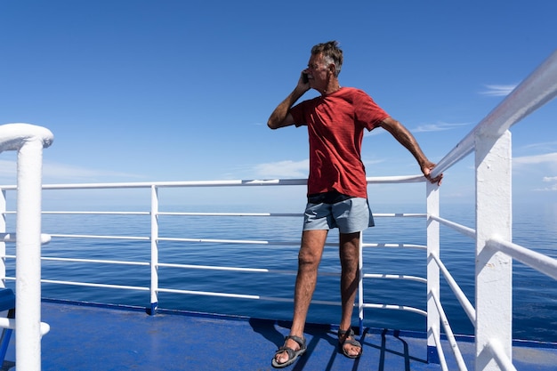 Older man talking on phone on sailboat