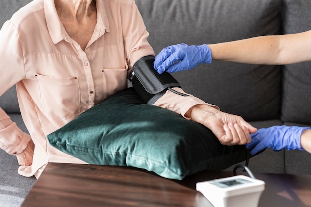 Older woman getting her blood pressure checked by nurse