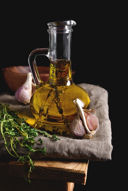 Olive oil in a glass bottle on dark background