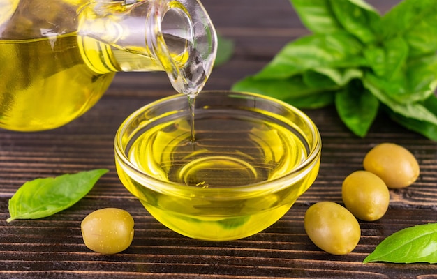 Olive oil is poured into a glass bowl close-up.