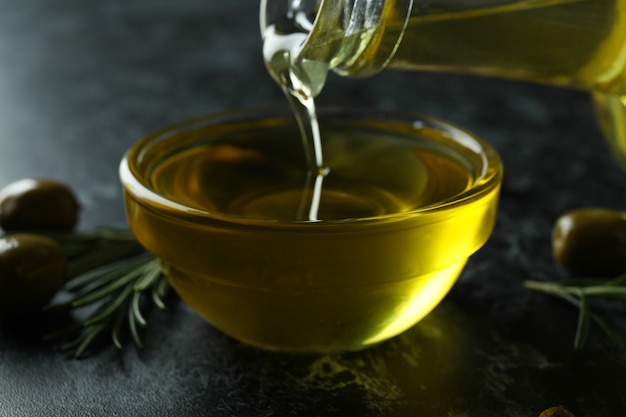 Olive oil pouring from bottle to bowl