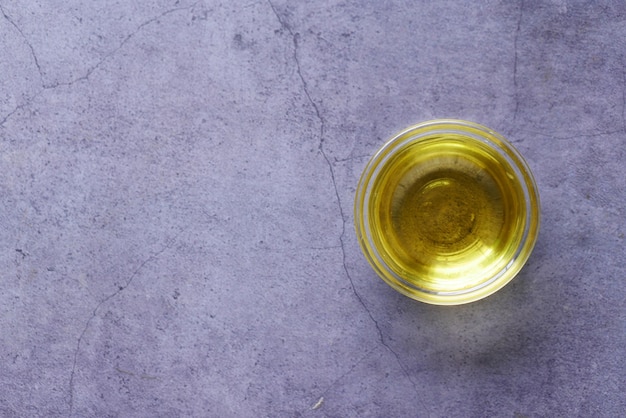 Olive oil in a small container on black background