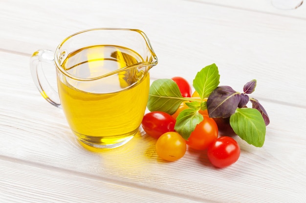 Olive oil tomatoes basil on wooden table