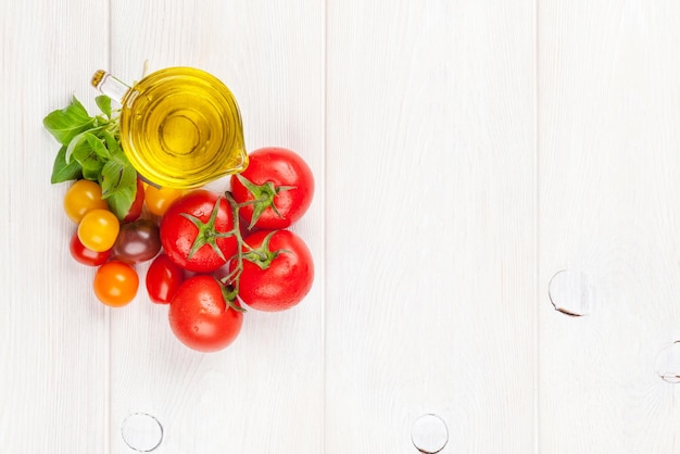 Olive oil tomatoes basil on wooden table