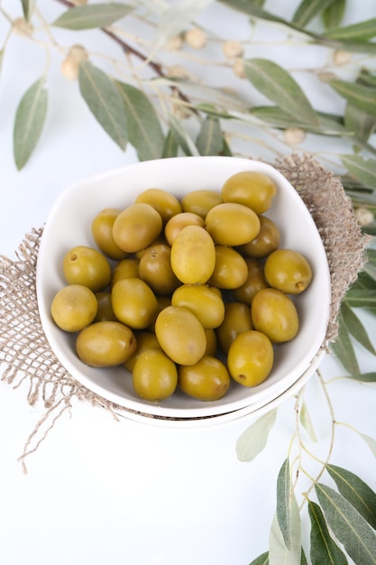 Olives in bowl with branch close up