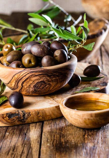 Olives and olive oil in wooden bowls