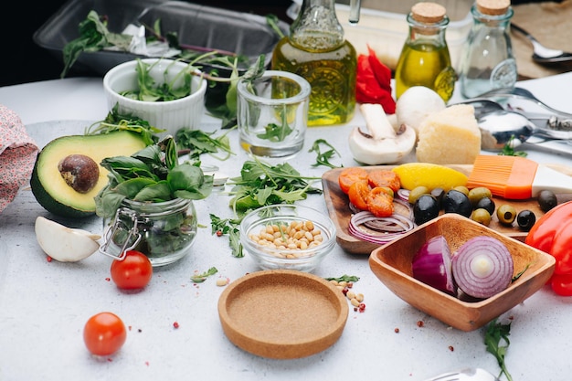 Olives onion greens oil pine nuts A table full with ingredients for salad