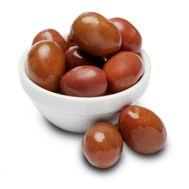 Olives in white bowl on white table