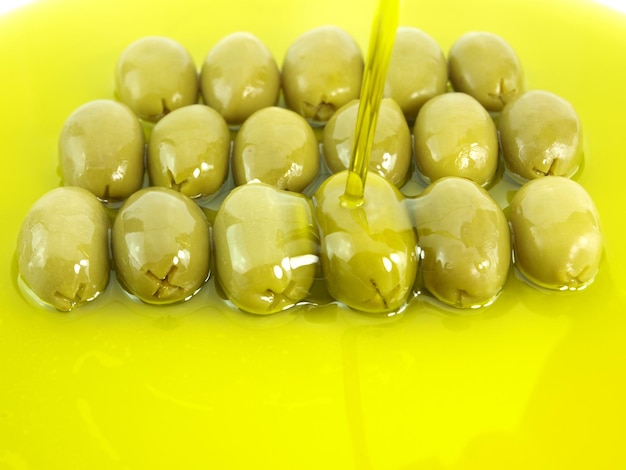 Olives with a drop of liquid being poured on them