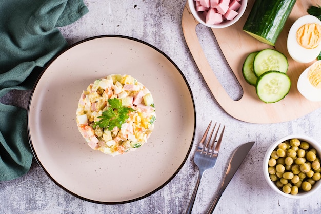 Olivier salad on a plate ingredients for its preparation on the table Christmas snacks Top view