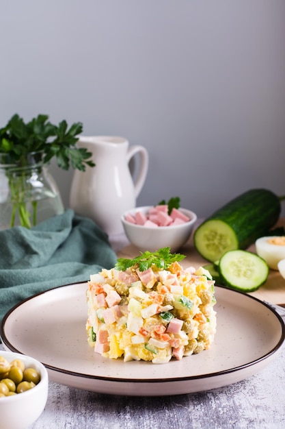 Olivier salad on a plate ingredients for its preparation on the table Christmas snacks Vertical