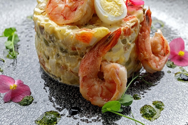 Olivier salad with shrimp and salmon on a plate