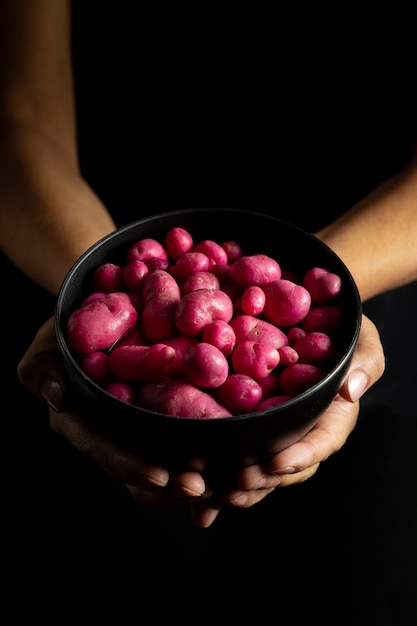 Olluco or chuguas in a black bowl held by hand