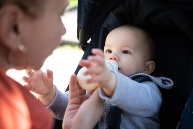 Om Feeding Infant Boy With Drink