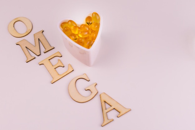 Omega-3 fish oil capsules are laid out with a heart on a white background.