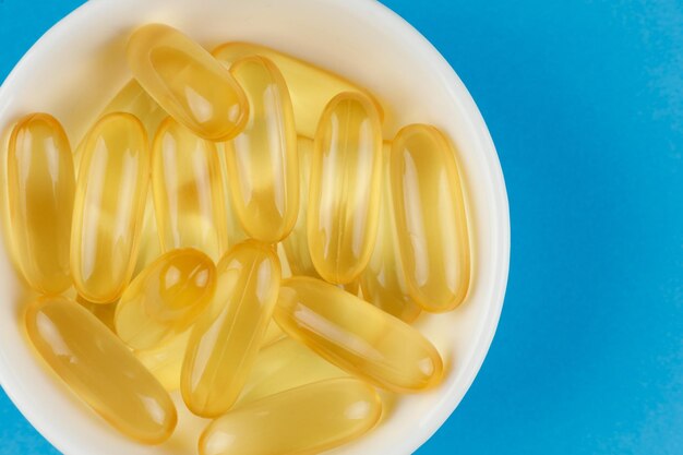 Omega 3 gelatin capsules in a white container