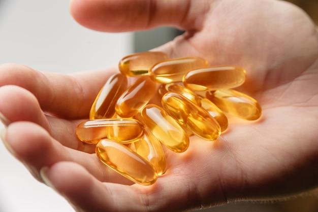 Omega3 capsules in a male palm closeup The concept of healthy food supplements