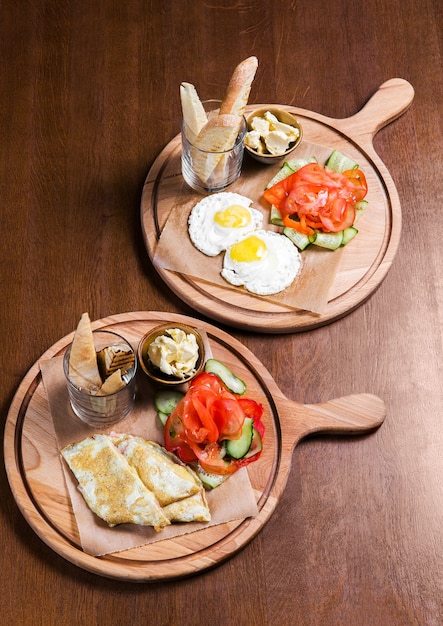 Omelette with vegetables and bread on wooden table in the restaurant. Tasty food. Gourmet