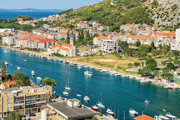 Omis town between hills and Cetina River with boats, Dalmatia, Croatia