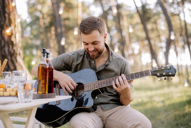 One bearded man is playing guitar Summer holidays vacation relax and lifestyle consept Camping time