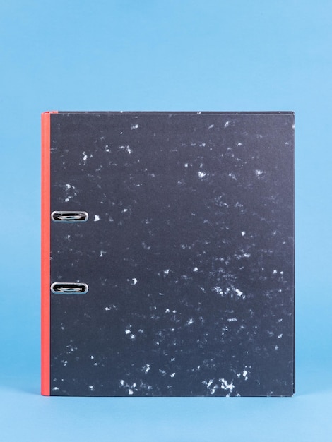 One black office folder isolated on blue close up