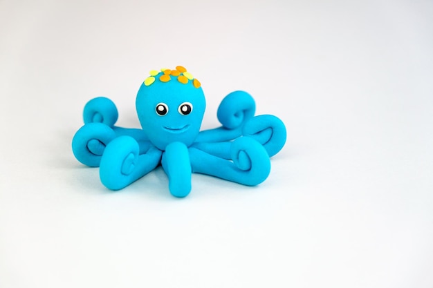 One blue plasticine octopus on white background children's games with modeling clay concept