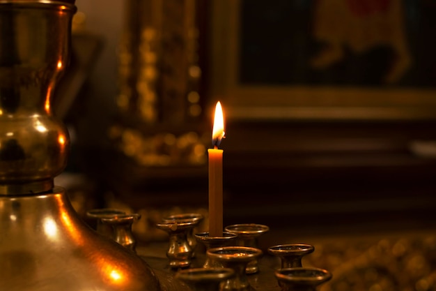 One candle on a stand in a church