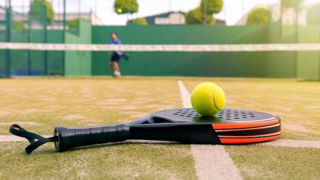 One caucasian mature man playing behind net with padel racket and yellow ball