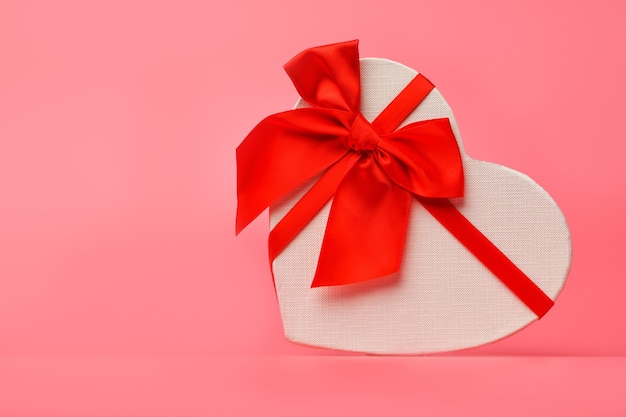 Photo one gift box with a red ribbon heart-shaped lying sideways