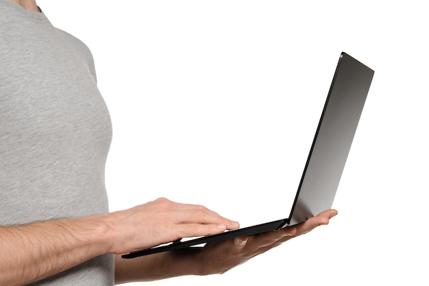 In one hand a man holds a laptop and the other is typing text on the keyboard Slim ultrabook in matte black with a touch screen