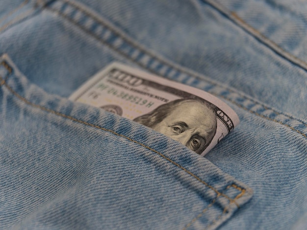 One hundred dollar banknote money in back pocket jeans pants