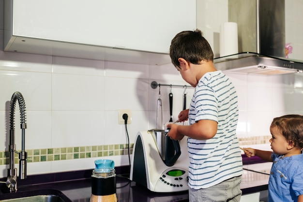 One kid preparing pancakes with a kitchen robot.