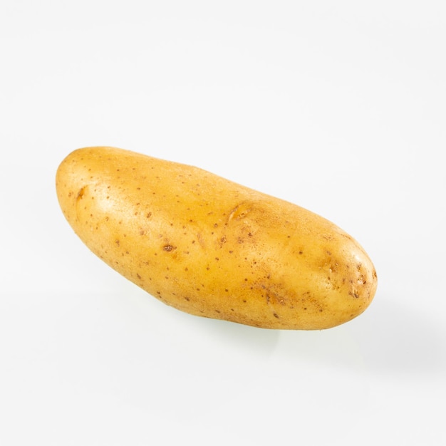 One large young potato on a white background closeup