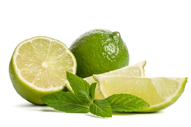 One lime with half of a juicy lime with leaves of mint isolated on white background