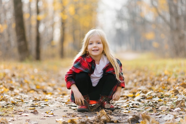 One little girl in the Park. Sunny autumn day in the city Park.