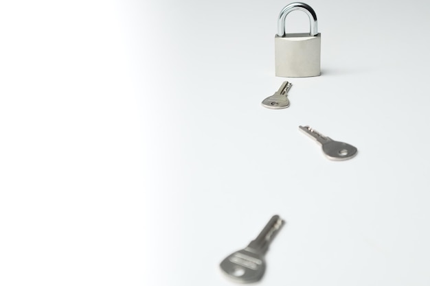 Photo one padlock with many another keys many keys and one lock as concept different metal keys and one hinged steel padlock on a white background