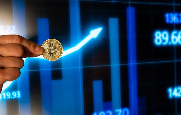 One person showing his fingers holding a cryptocurrency bitcoin with stock market charts in the background