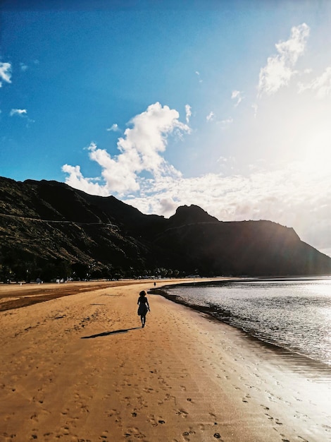 One person walking at the sand beach in silhouette alone enjoying travel lifestyle and summer holiday vacation in tropical scenic destination Leisure and outdoors