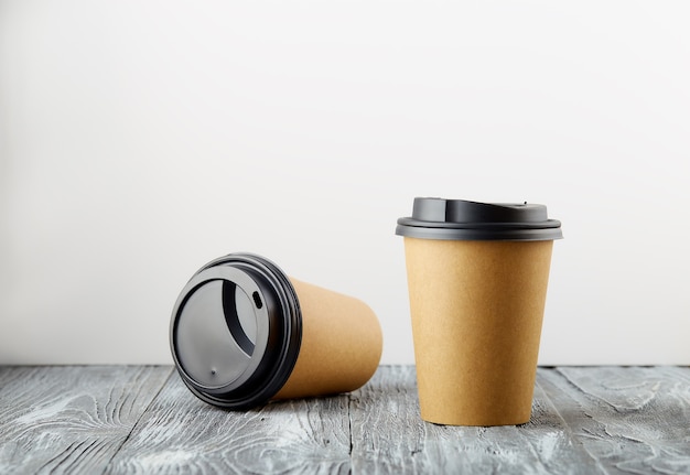 One rest and one cost take away paper coffee cups on grey wooden background