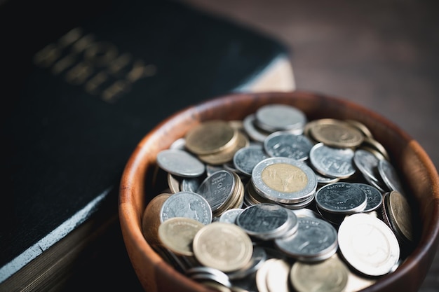 One tenth or tithe is basis on which Bible teaches us to give one tenth of first fruit to God coins with Holy Bible Biblical concept of Christian offering generosity and giving tithes in church