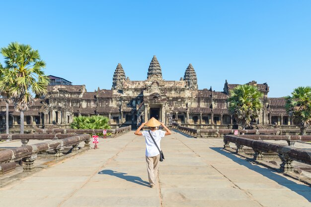 One tourist visiting Angkor Wat ruins at sunrise