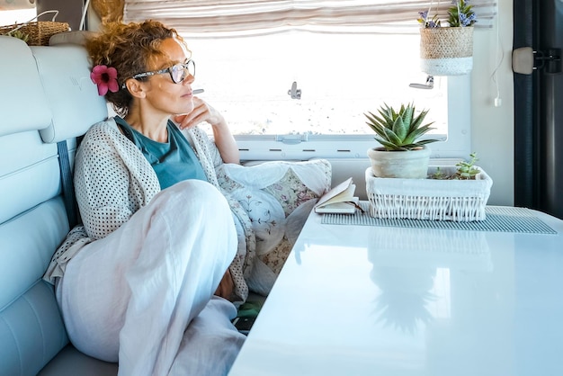 Photo one traveler woman having relax inside modern camper van renting rv vehicle for alternative tiny house or travel vacation vanlife adult people lifestyle one female resting and enjoying destination