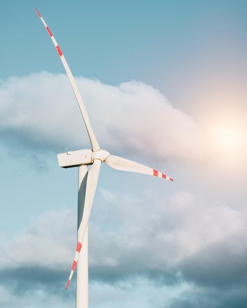 One turbine mill Wind turbine in the green field against blue sky with fluffy clouds Concept of green energy and sustainable future