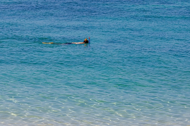 One woman is snorkeling for shallow coral reefs