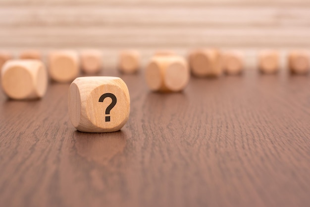 One wooden block with a question mark and a reflection from the table surface